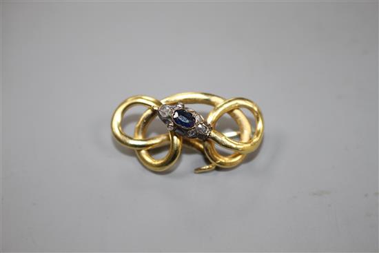 A late Victorian yellow and white metal, sapphire and diamond set scrolling serpent brooch, 32mm, gross 4.5 grams.
